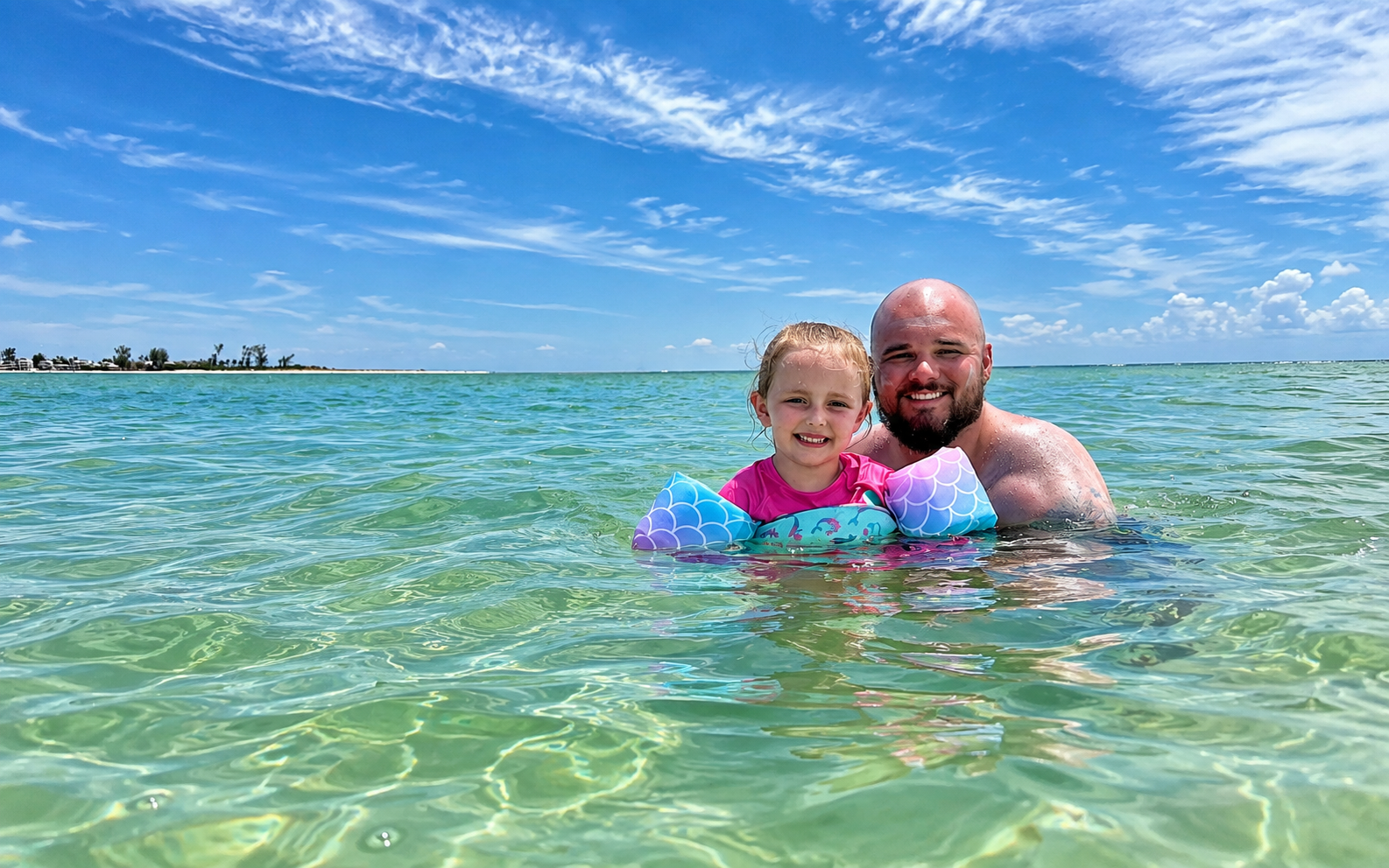 Father and daughter enjoying clear Gulf water near Holmes Beach